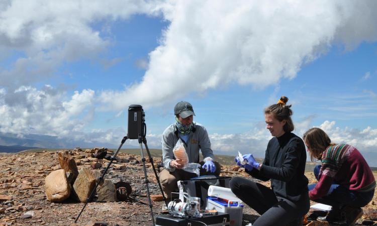 Female student tests soil quality in a field test in Bolivia.