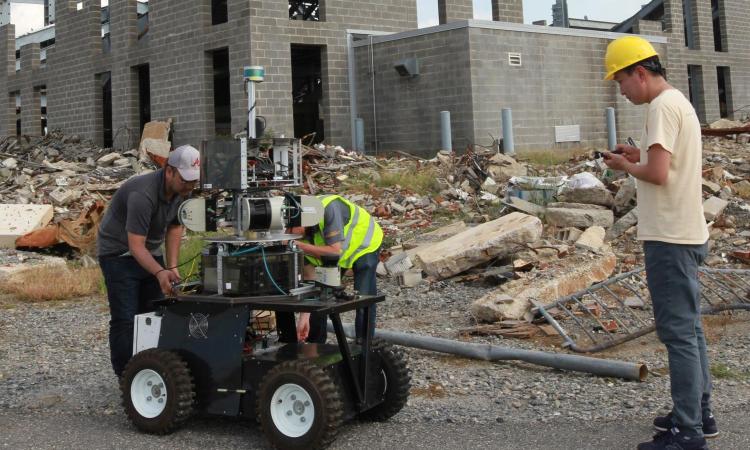 Men working on a robot at a construction site