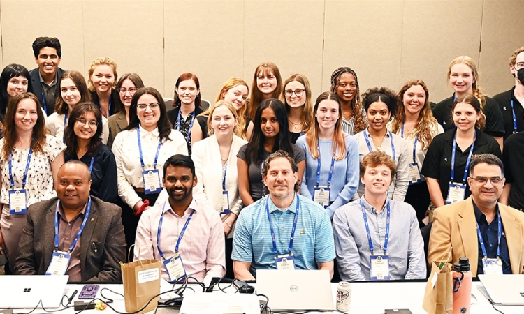 Group of students who competed in the 2024 GAWP student competition standing behind the seated judges panel.