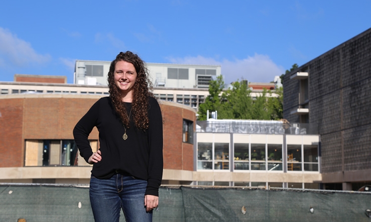 Rachel Brashear, a fourth-year civil engineering undergraduate, stands in front of the Van Leer Building and the under-construction Interdisciplinary Design Commons. Brashear has been working as the project's on-site engineer with Gilbane Building Company. (Photo: Jess Hunt-Ralston)