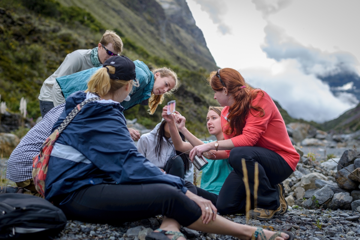 A group of people gathered with a mountain in the background