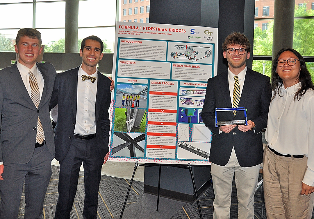 Four students, three men and one woman, pose with their Capstone project