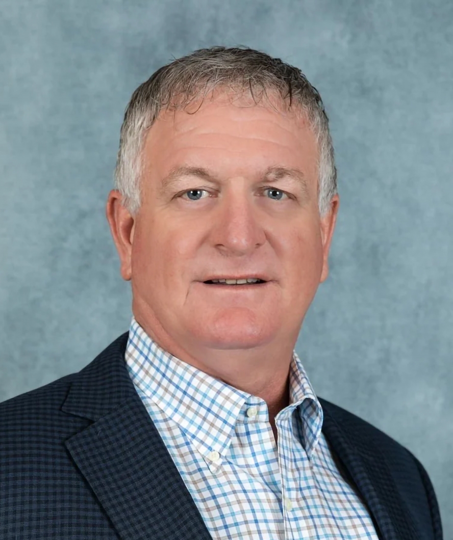 Portrait of Garland Long in a blue blazer and a white checked dress shirt