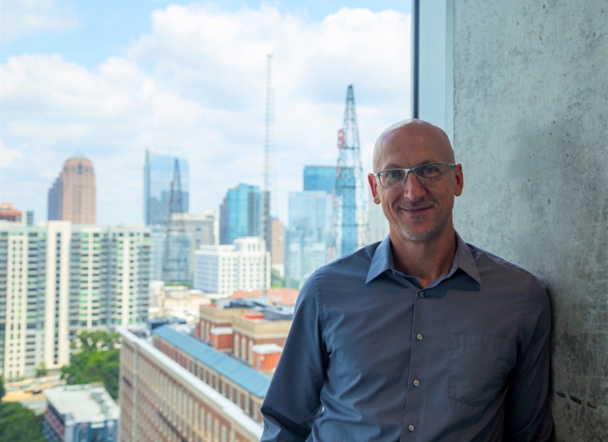 A portrait of a man in front of a city skyline