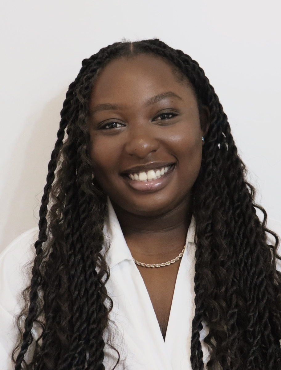 Portrait of Kathryn Owusu in a white blouse with a gold necklace