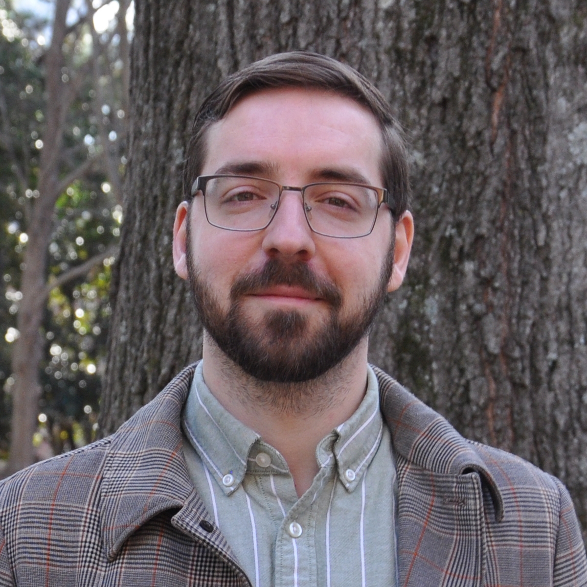 Portrait of Edvard Bruun wearing a green striped shirt and a light brown checked overcoat
